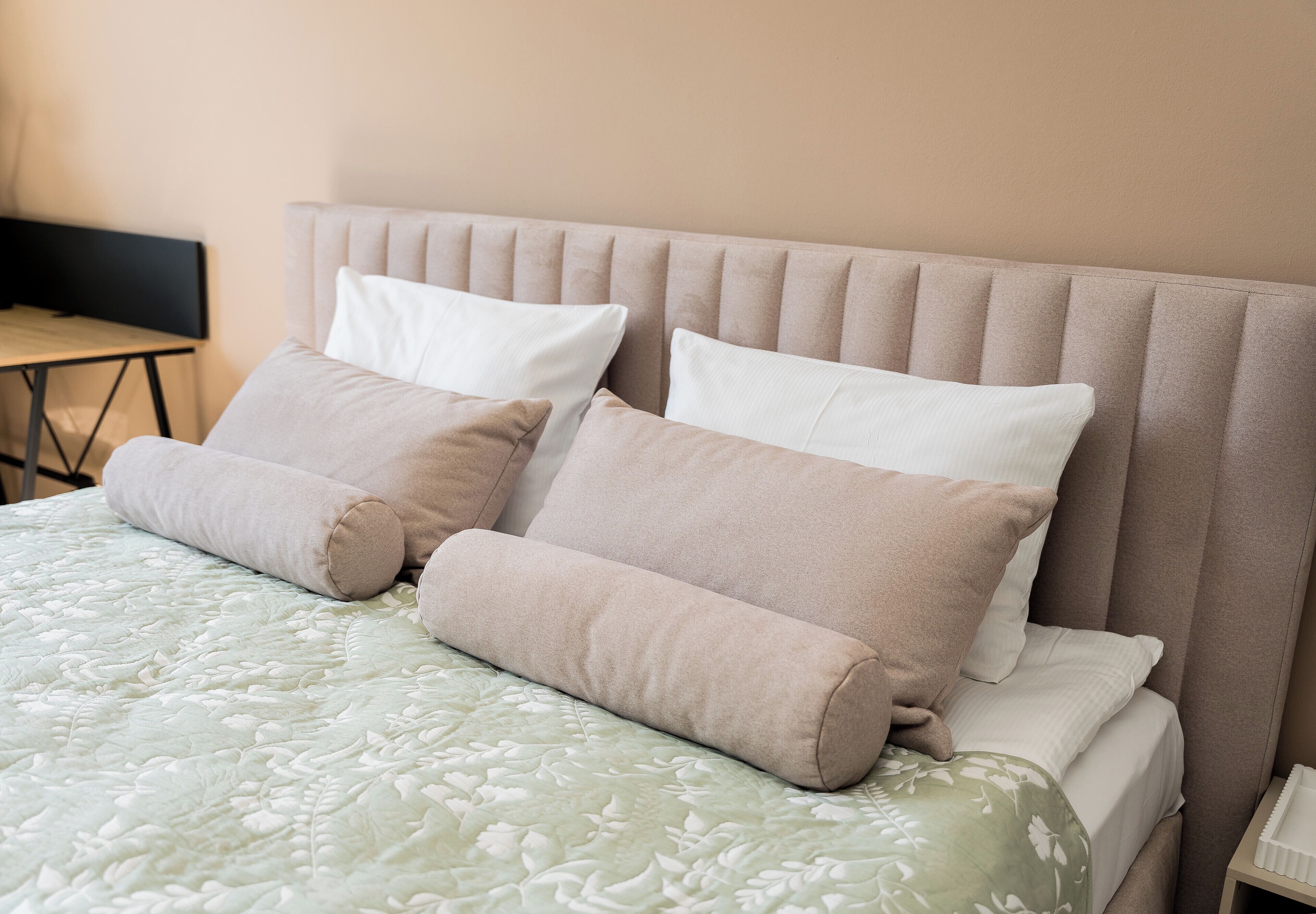 A neatly made bed with a patterned bedspread and two pillows.