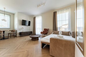 A modern hotel room with a bed, seating area, TV, and large windows. - Ogrody Tesoro 52 Apartment (Pogórze)