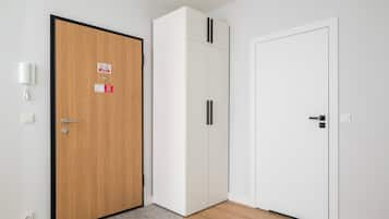 Ein Zimmer mit einer Holztür, einem weißen Wandschrank und einem weißen Kleiderschrank.