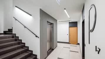 Ein modernes Interieur mit einer Treppe, einer Tür und einer Wandleuchte.