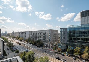A city street with modern buildings, a tram, and a clear sky. - Marszałkowska City View Apartment (Warszawa)