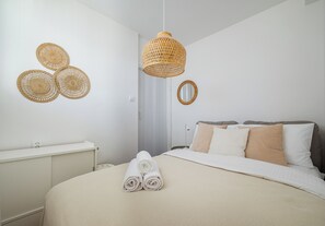 A neatly arranged bedroom with a bed, a hanging light fixture, and a wall-mounted mirror. - Marszałkowska City View Apartment (Warszawa)