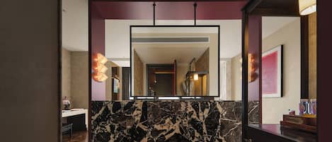 A modern bathroom with a marble vanity, a large mirror, and a patterned floor.