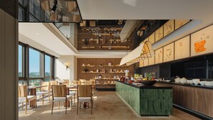 Un intérieur moderne comprenant un coin repas, une cuisine et une vue sur l’extérieur.