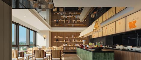 A modern interior with a dining area, kitchen, and a view of the outdoors.