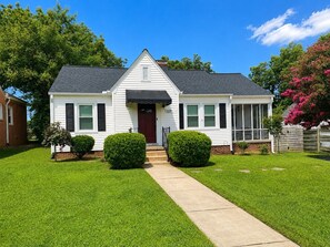 A single-story house with a front entrance, a visible number '519' on the side, and a well-maintained lawn. - Charming Historic Bungalow in Emerywood - High Point's Sought-After Neighborhood (High Point)