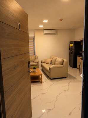 A modern living room with a sofa, a coffee table, and a wooden cabinet. - Enjoyable 1-bedroom apartment with AC in lovely Oranjestad (Oranjestad)