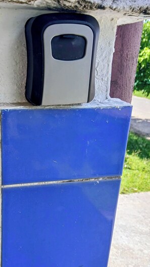 A blue tiled wall with a black and white object mounted on it. - LE MILANO (Kourou)