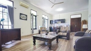 Uma sala de estar ampla com mesa de centro de madeira, sofás e televisão.