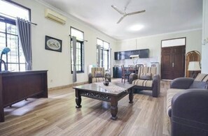 Un amplio salón con una mesa de centro de madera, sofás y una televisión.