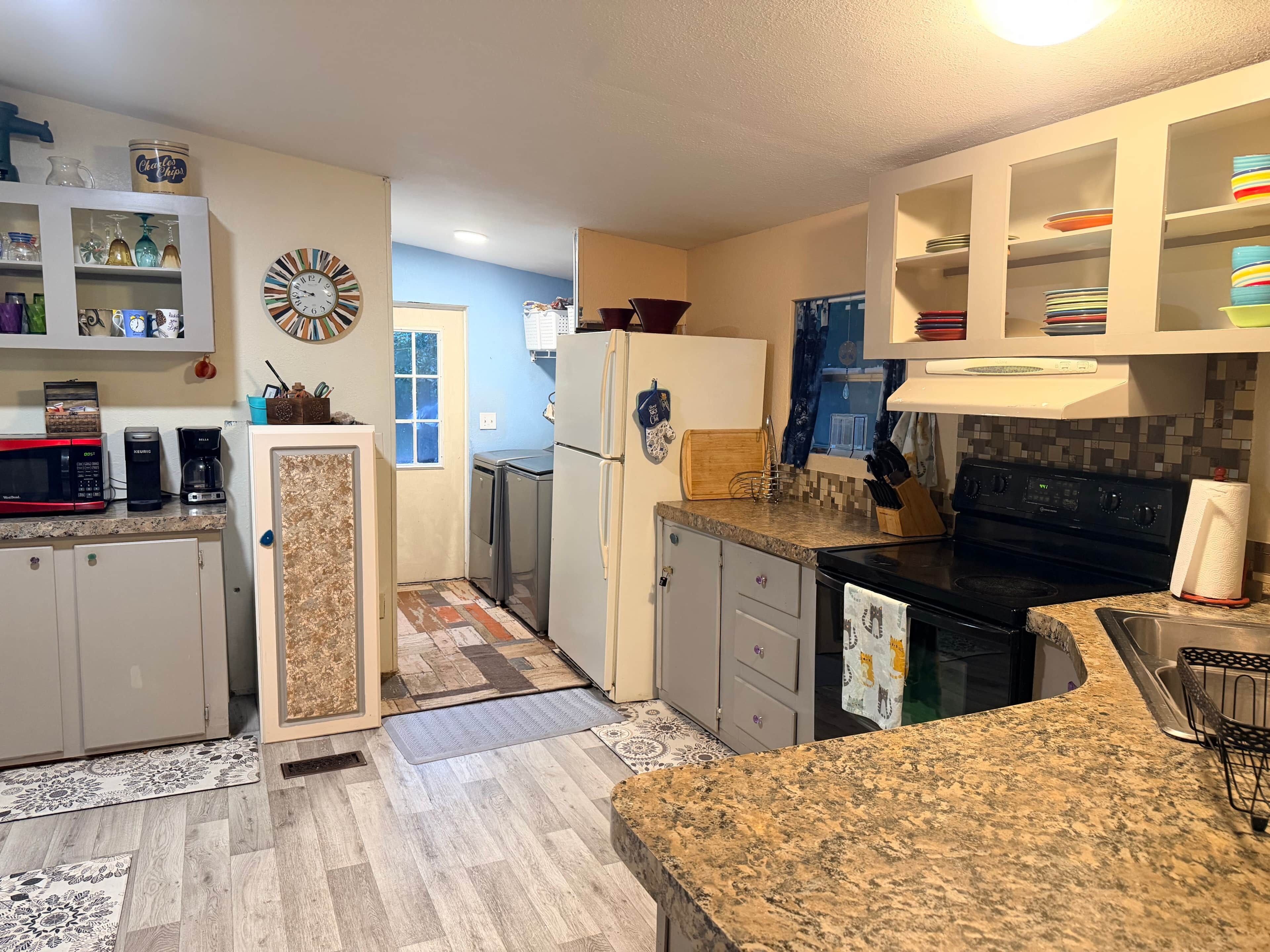 Una cocina compacta con microondas, cafetera y refrigerador.