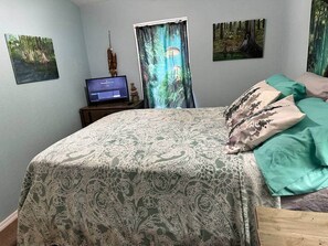 A bedroom with a bed, a desk with a computer, and three framed pictures on the wall. - Nature Cabin Itchetucknee Springs Private Access (Columbia County)