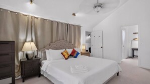 A hotel room with a large bed, a nightstand, a lamp, and a wardrobe. - Stylish 2BR Near Bellevue & Kirkland w/ Pool+AC (Bellevue)