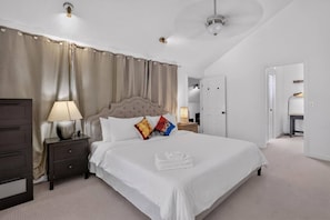 Een hotelkamer met een groot bed, een nachtkastje, een lamp en een kledingkast.