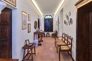 Un pasillo con una puerta de madera, una mesa de comedor con sillas y una ventana con vistas.