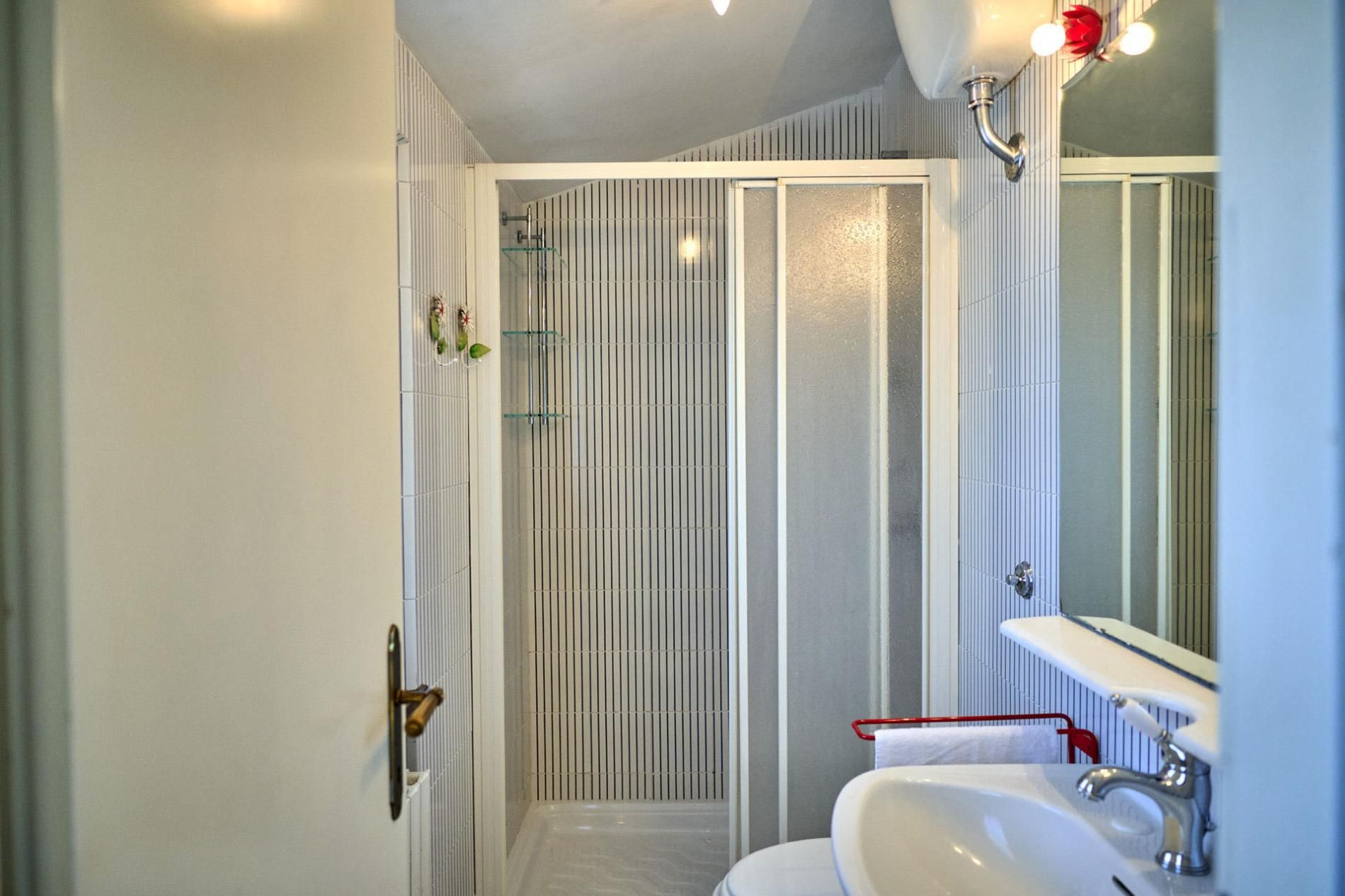 Ein Badezimmer mit Dusche, Waschbecken und Spiegel.
