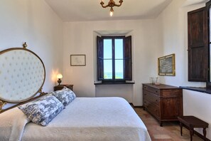Ein Schlafzimmer mit Bett, Schminktisch, Fenster mit Blick und einer Kristallleuchtre.