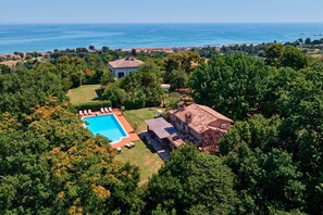 Ein Wohnhaus mit Pool, Terrasse und Meerblick.