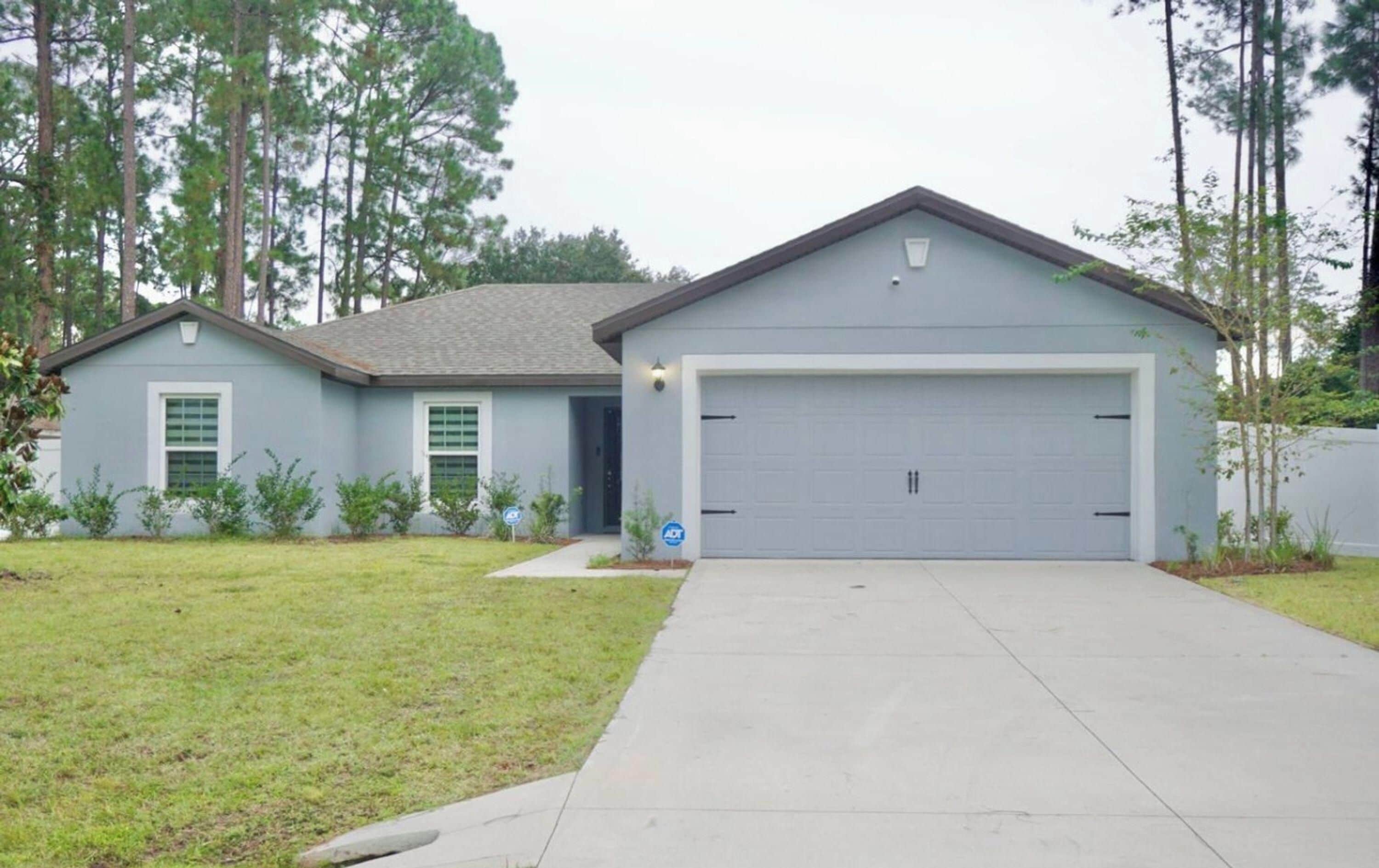 A single-story house with a garage and a front lawn.