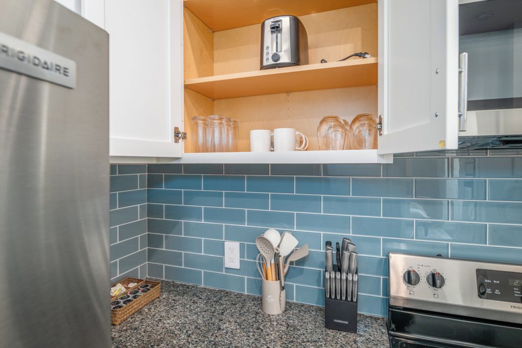 A kitchen with a stainless steel refrigerator, a toaster, and a coffee maker on the countertop.