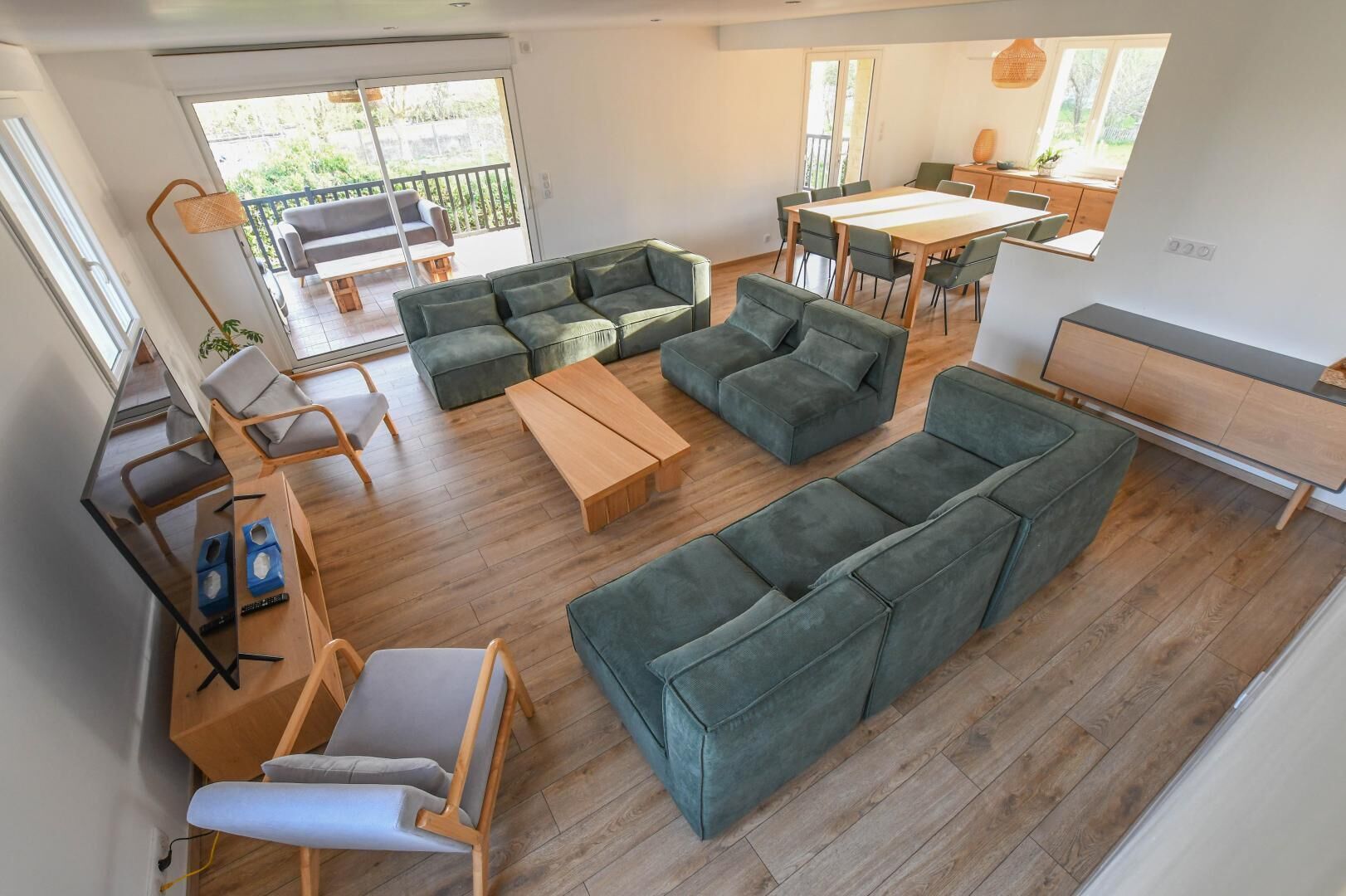 Een moderne woonkamer met een zithoek, een eettafel en een keuken.