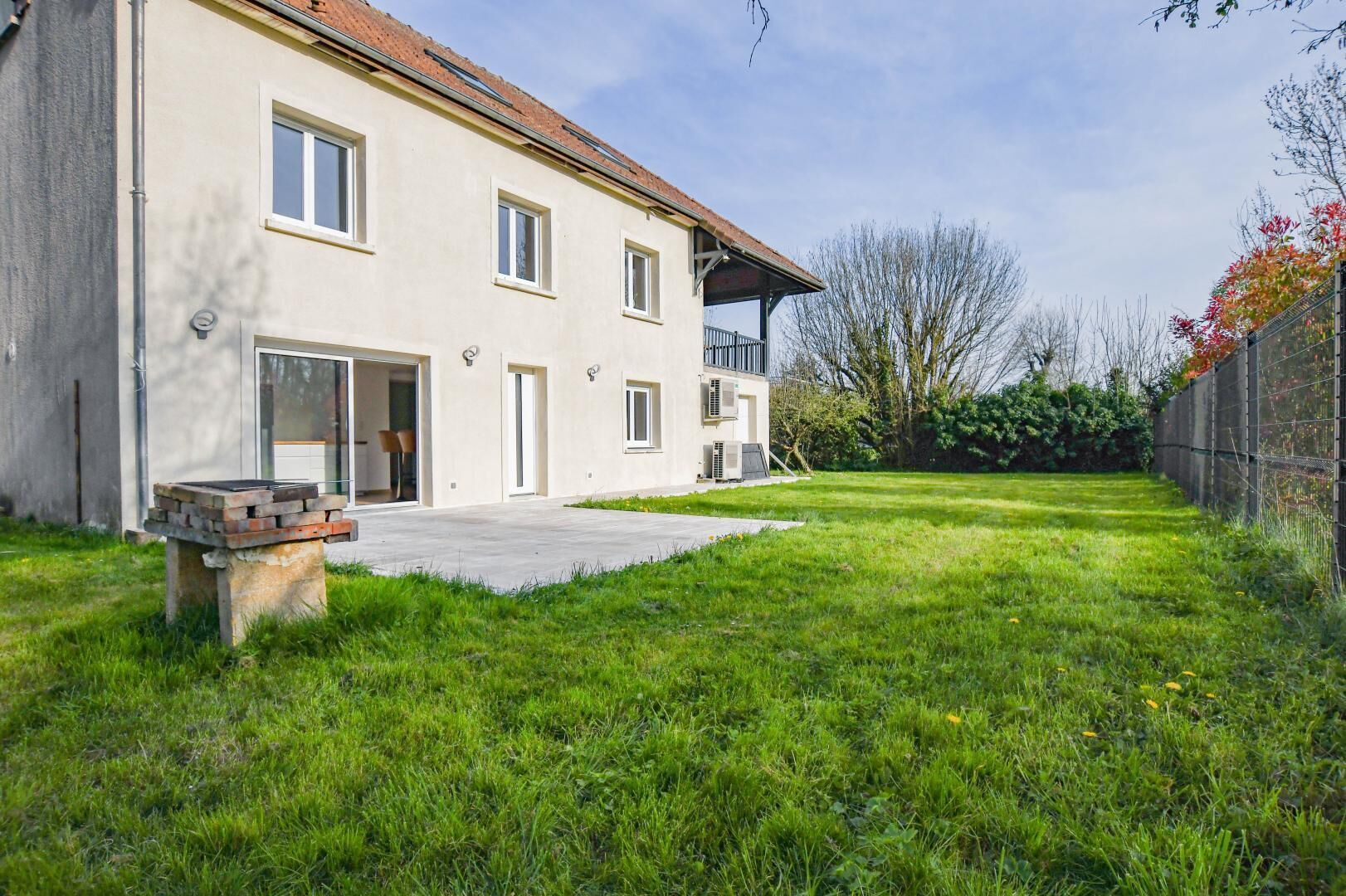 A two-story building with a flat roof, a paved driveway, and a grassy yard.