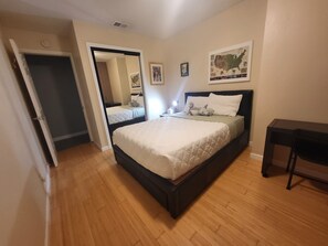 A bedroom with a bed, a nightstand, a dresser, a mirror, and a wall-mounted map. - Spacious House near Disney/Knott's (La Mirada)