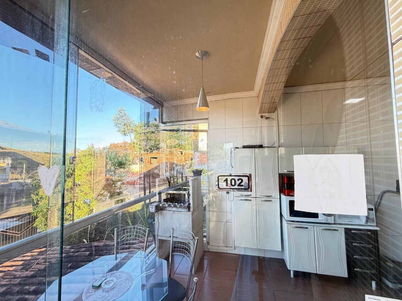 Cozinha moderna com vista para a cidade, um aviso de número e um lustre.