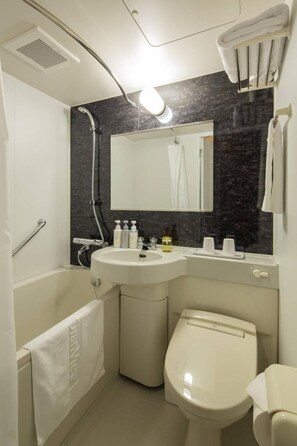 A modern bathroom with a bathtub, a sink, a toilet, and a mirror. - (Fukuoka)