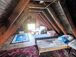 An attic room with a sloped ceiling, a bed, a small table, and a chair. - Oaza spokoju by Interhome (Borszowice)