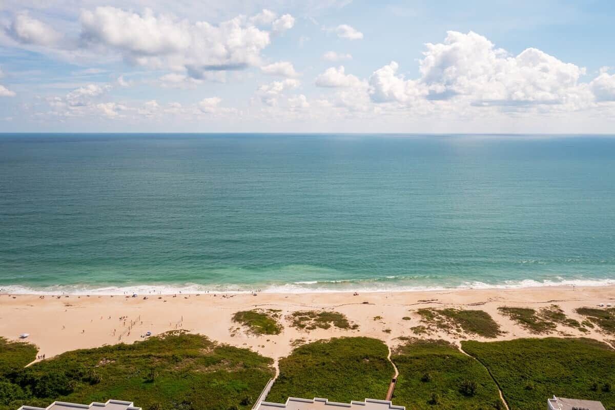 A beach with a clear view of the ocean and a path leading to the water.