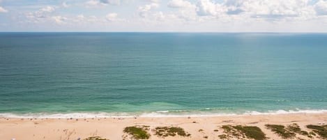 A beach with a clear view of the ocean and a path leading to the water.