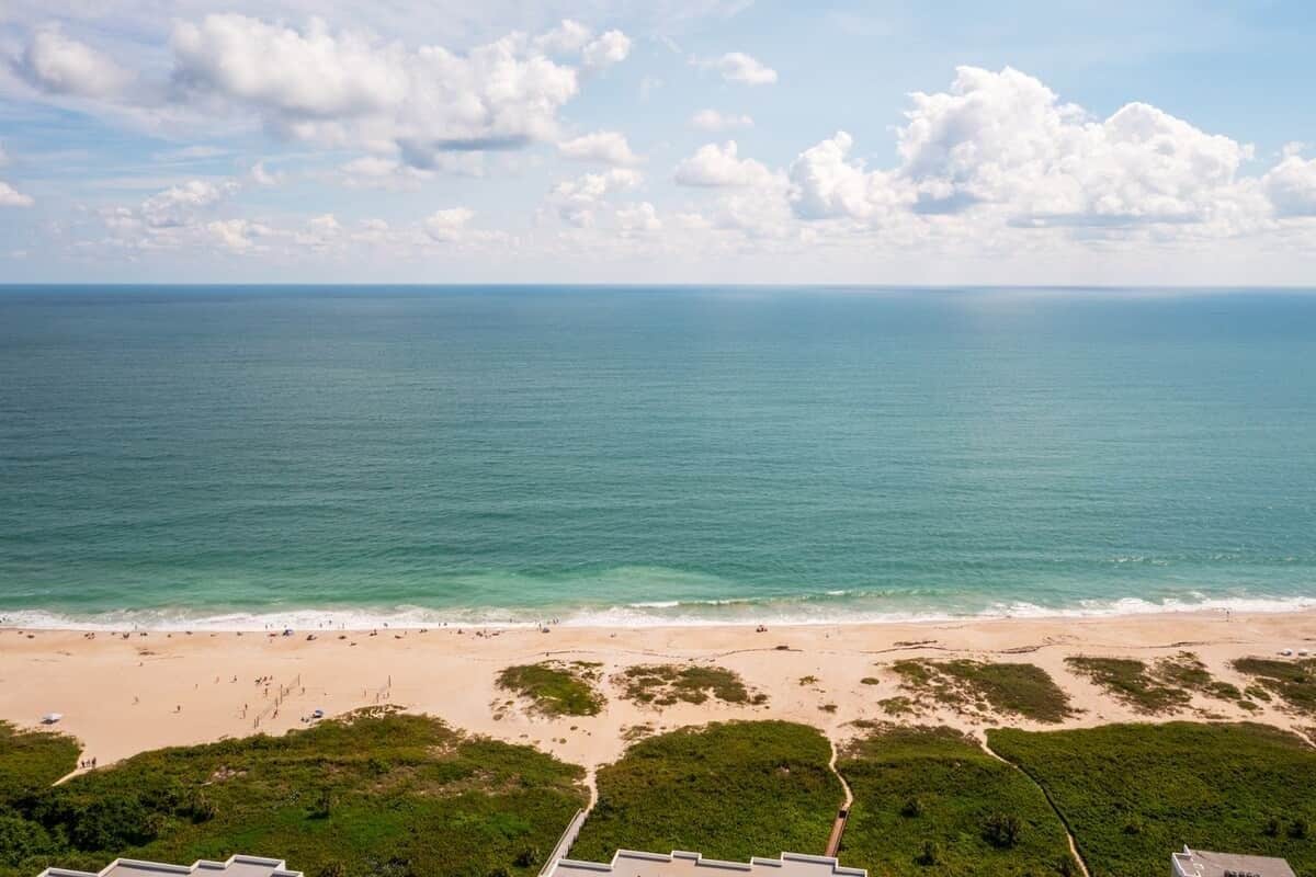 A beach with a clear view of the ocean and a path leading to the water.