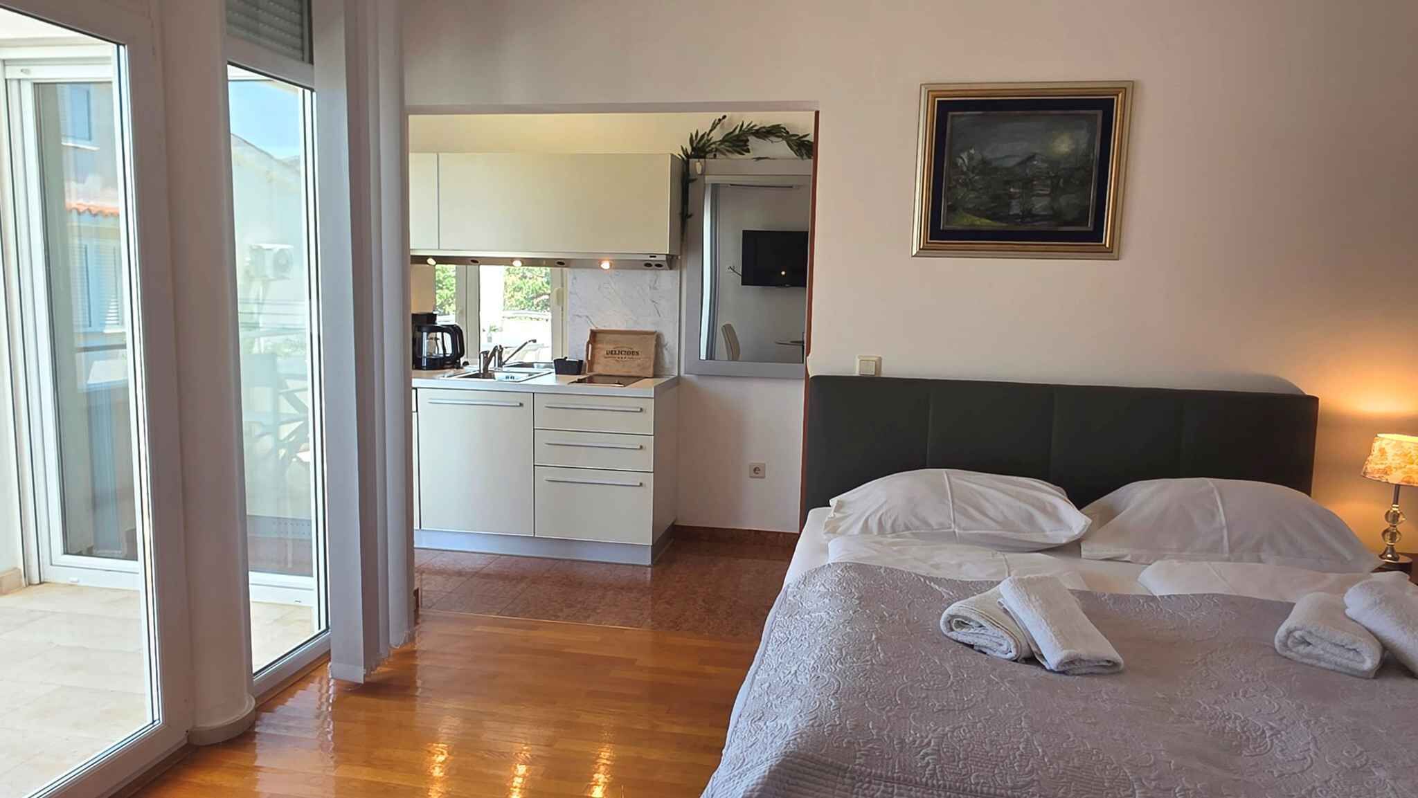 Une chambre d’hôtel avec un lit, une table de chevet, un tableau et une vue sur l’extérieur.