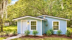 A small, single-story house with a front door, two windows, and a porch.