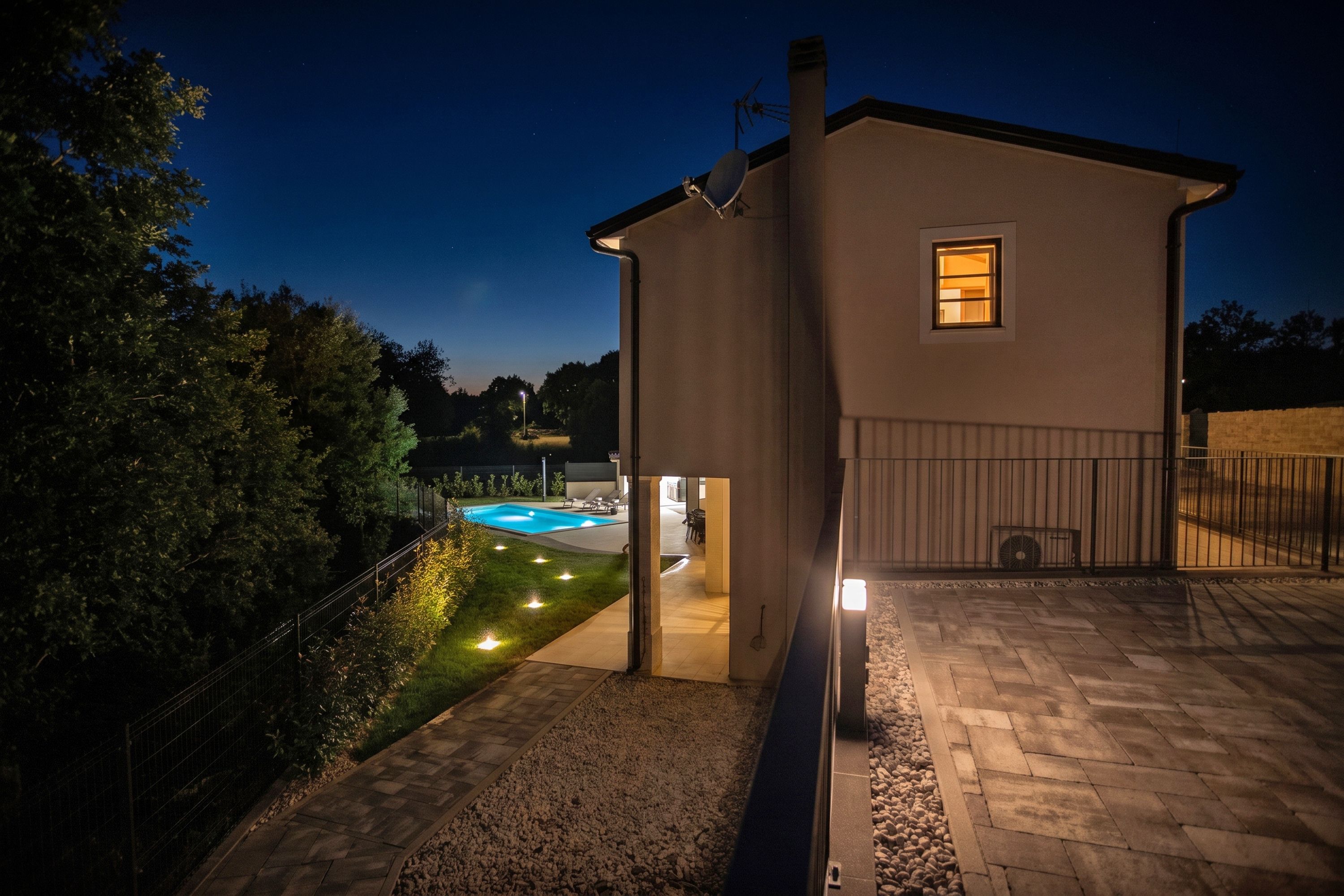 A modern house with a swimming pool, a covered patio, and a well-maintained garden.