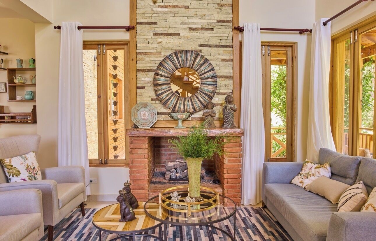 A living room with a fireplace, a round mirror, and a coffee table.
