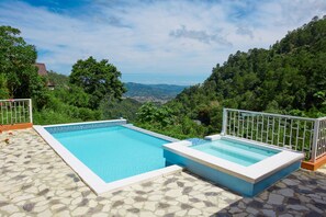A rectangular swimming pool with a tiled edge, surrounded by a stone patio. - Vrbo Property (Jarabacoa)