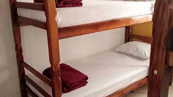 Una cama litera con dos niveles, cada uno con una almohada y un edredón doblado.