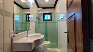 Un baño moderno con tocador, inodoro y cabina de ducha.