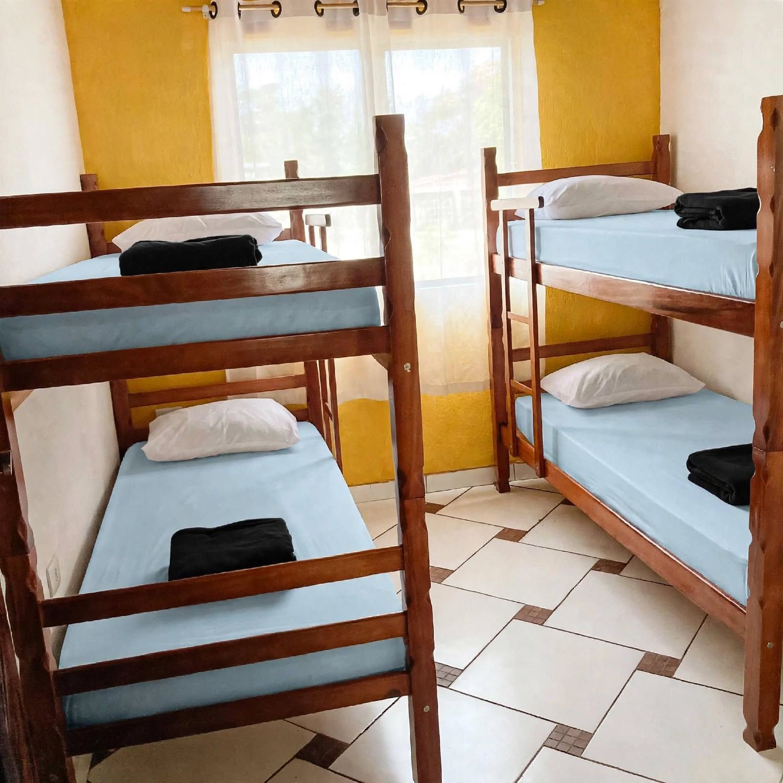 A room with bunk beds, a window with curtains, and a tiled floor.
