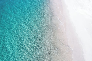 Una playa con agua turquesa cristalina y arena blanca.