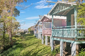 Una hilera de casas de madera tradicionales con balcones, en un paisaje verde y exuberante.