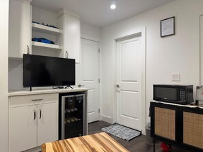 A compact living space with a kitchenette, a flat-screen TV, a refrigerator, a microwave, and a small table. - South Surrey Suite! 
Close to recreation, Morgan crossing, white rock beach! (Surrey)