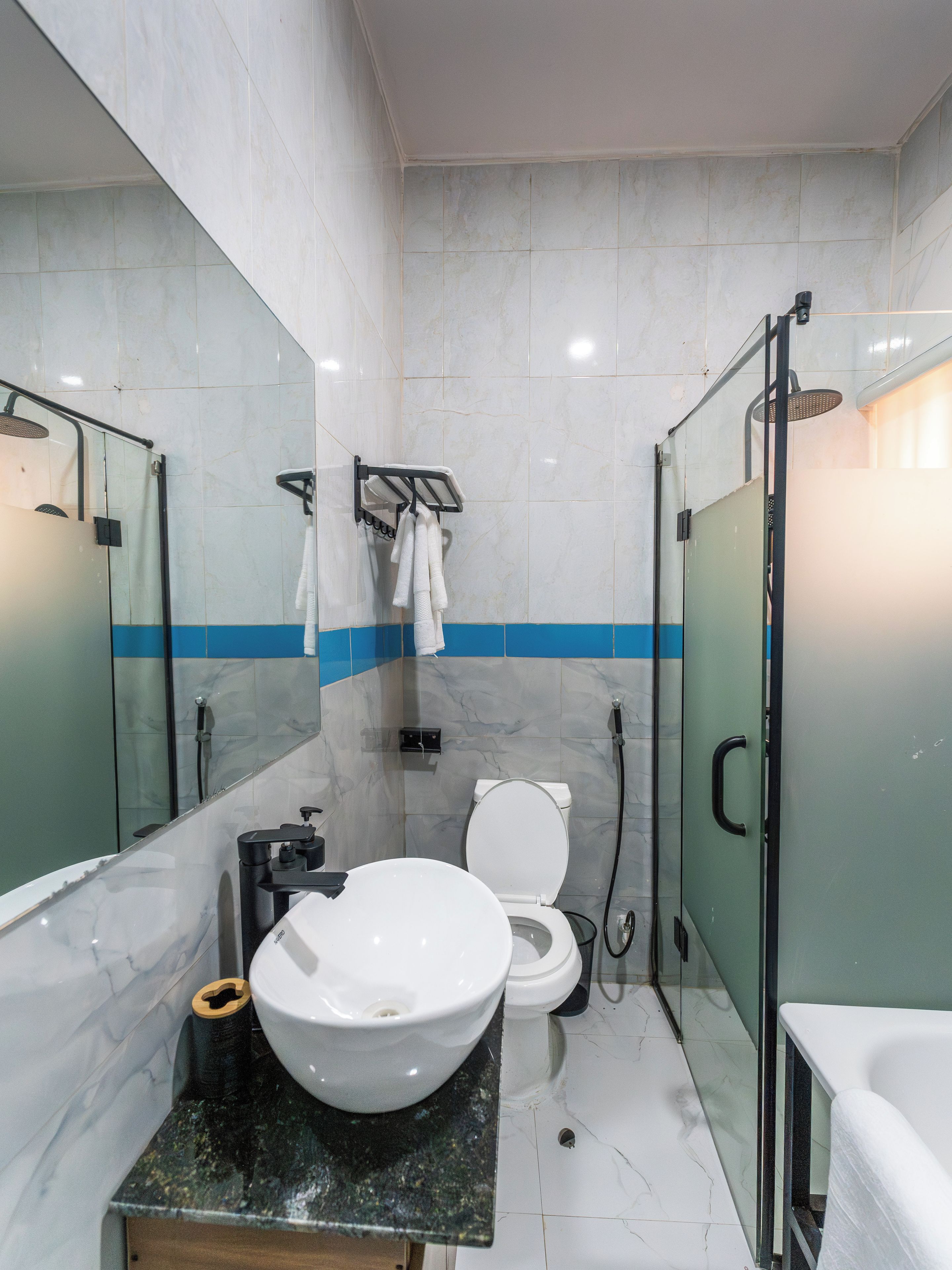 Un baño moderno con un lavamanos grande, inodoro y zona de ducha.