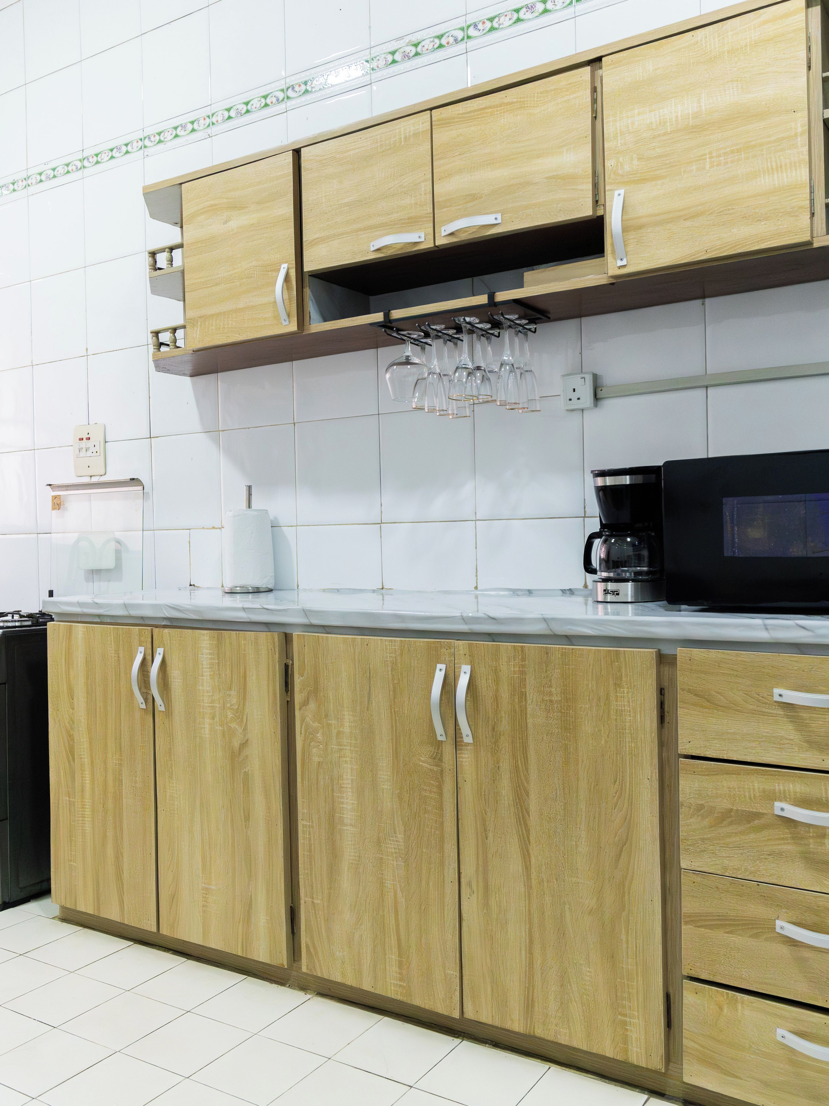 Una cocina con armarios de madera, una encimera, una cafetera y un microondas.