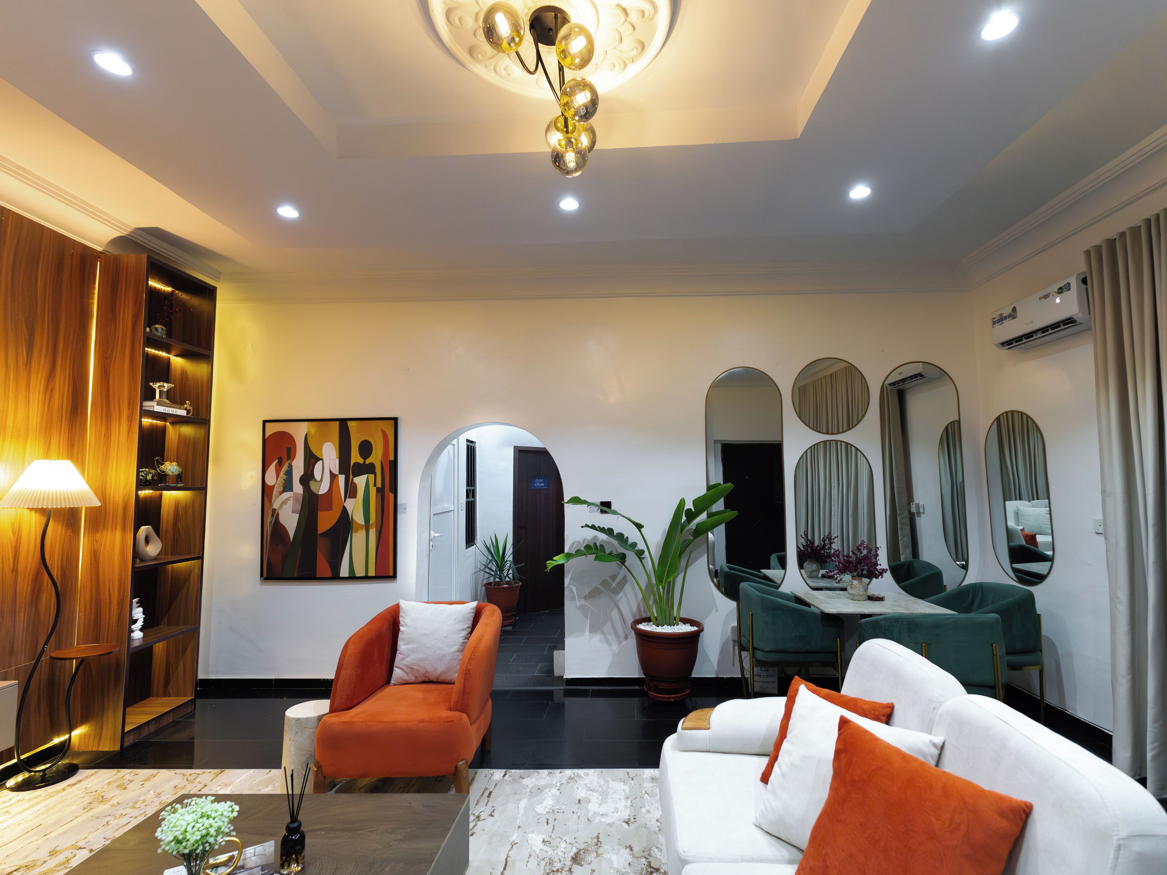 Een moderne hotel lobby met een receptiebalie, zithoek en een groot schilderij aan de muur.