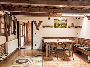 Ein rustikales Interieur mit einer hölzernen Bank, einem Tisch und einem Gemälde an der Wand.