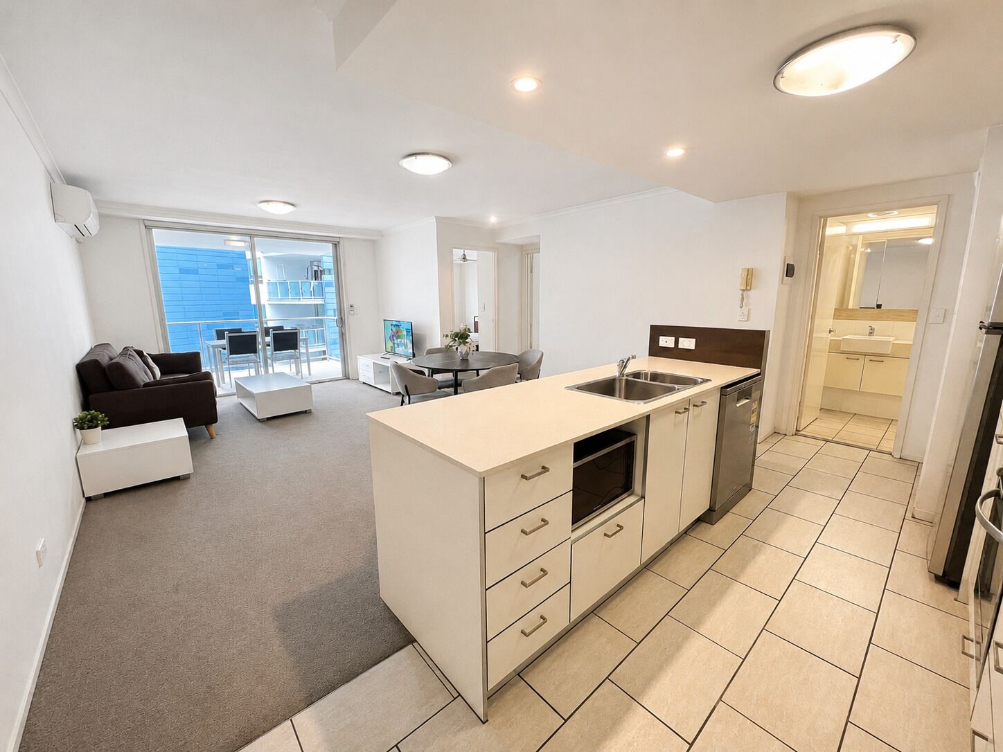 Een modern appartement met keuken, eethoek en woonkamer.