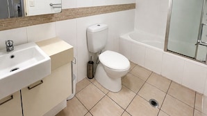 A bathroom with a sink, toilet, and bathtub. - River Glimpse 2BR Walk to CBD & Parking (Brisbane City)